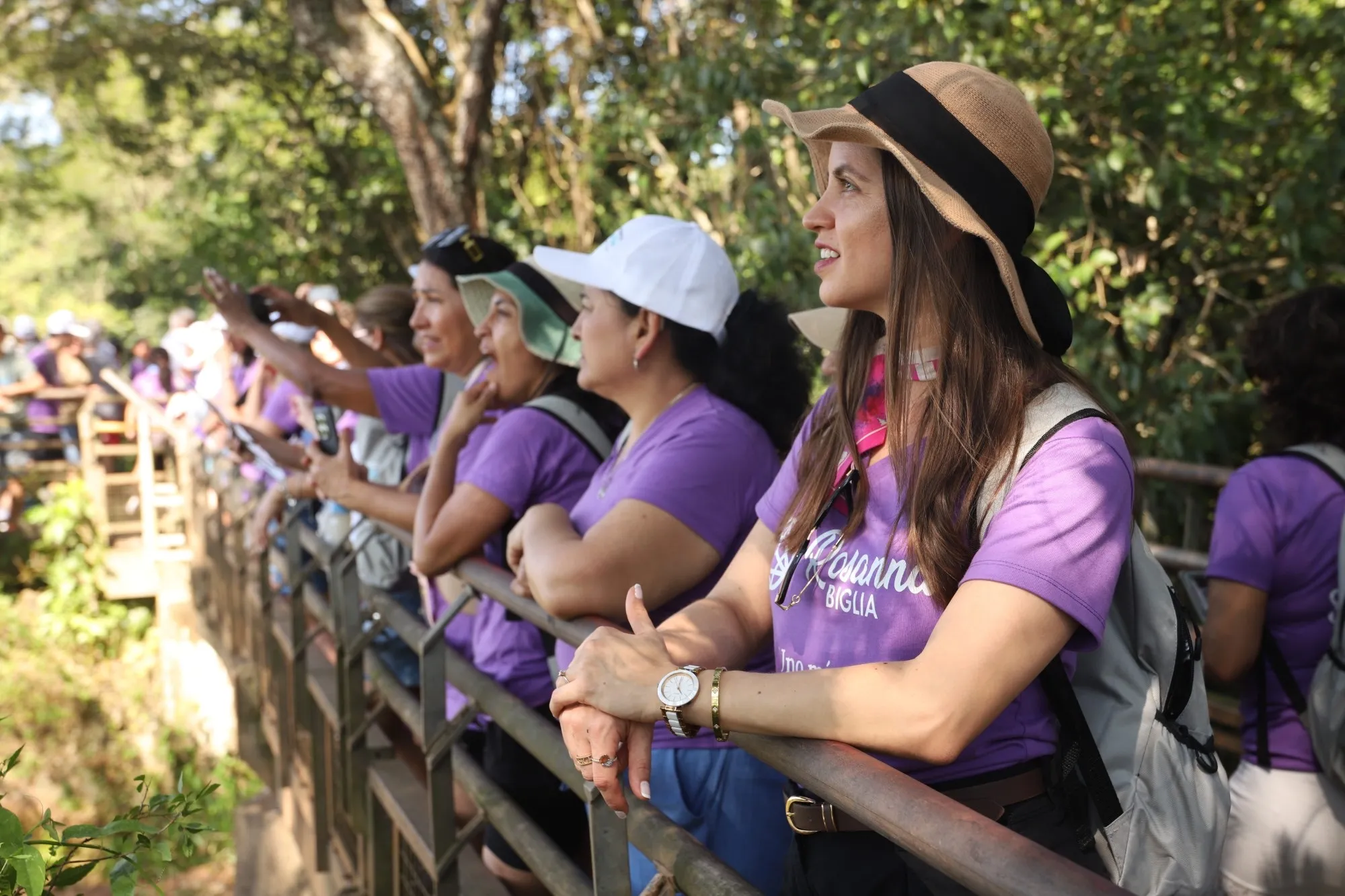 Participantes de una experiencia anterior contemplando el paisaje desde una pasarela en la selva
